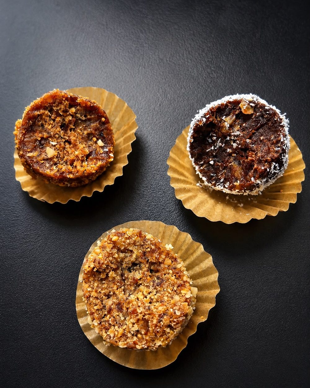 Three homemade date balls on paper cups